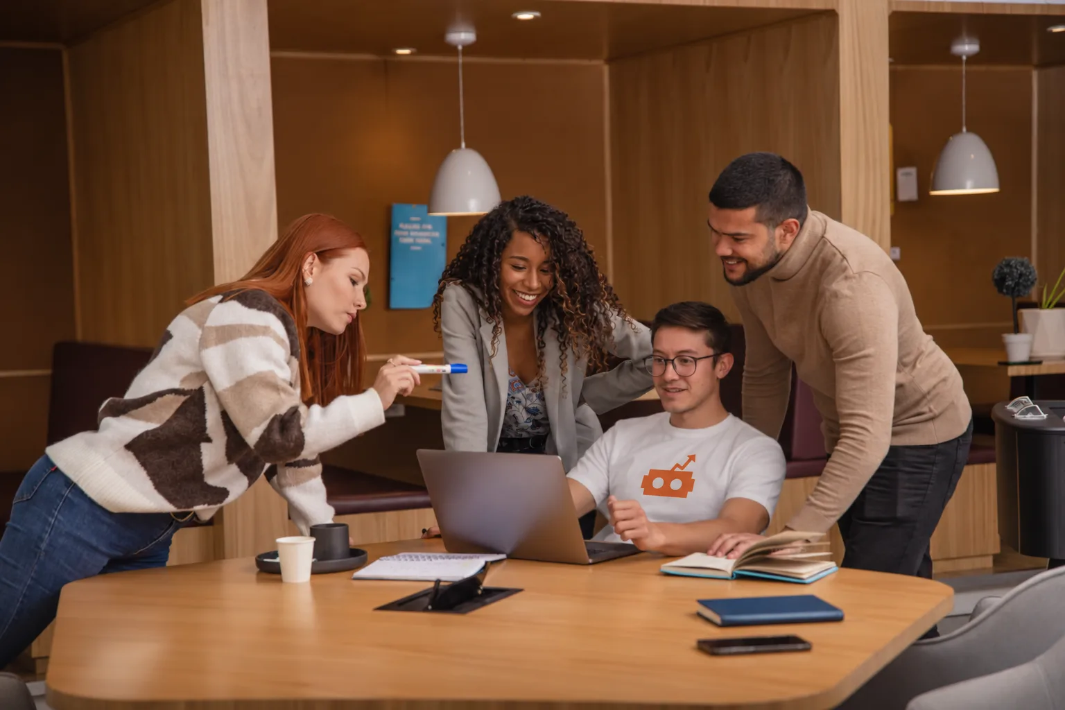 Four colleagues gathered around a laptop